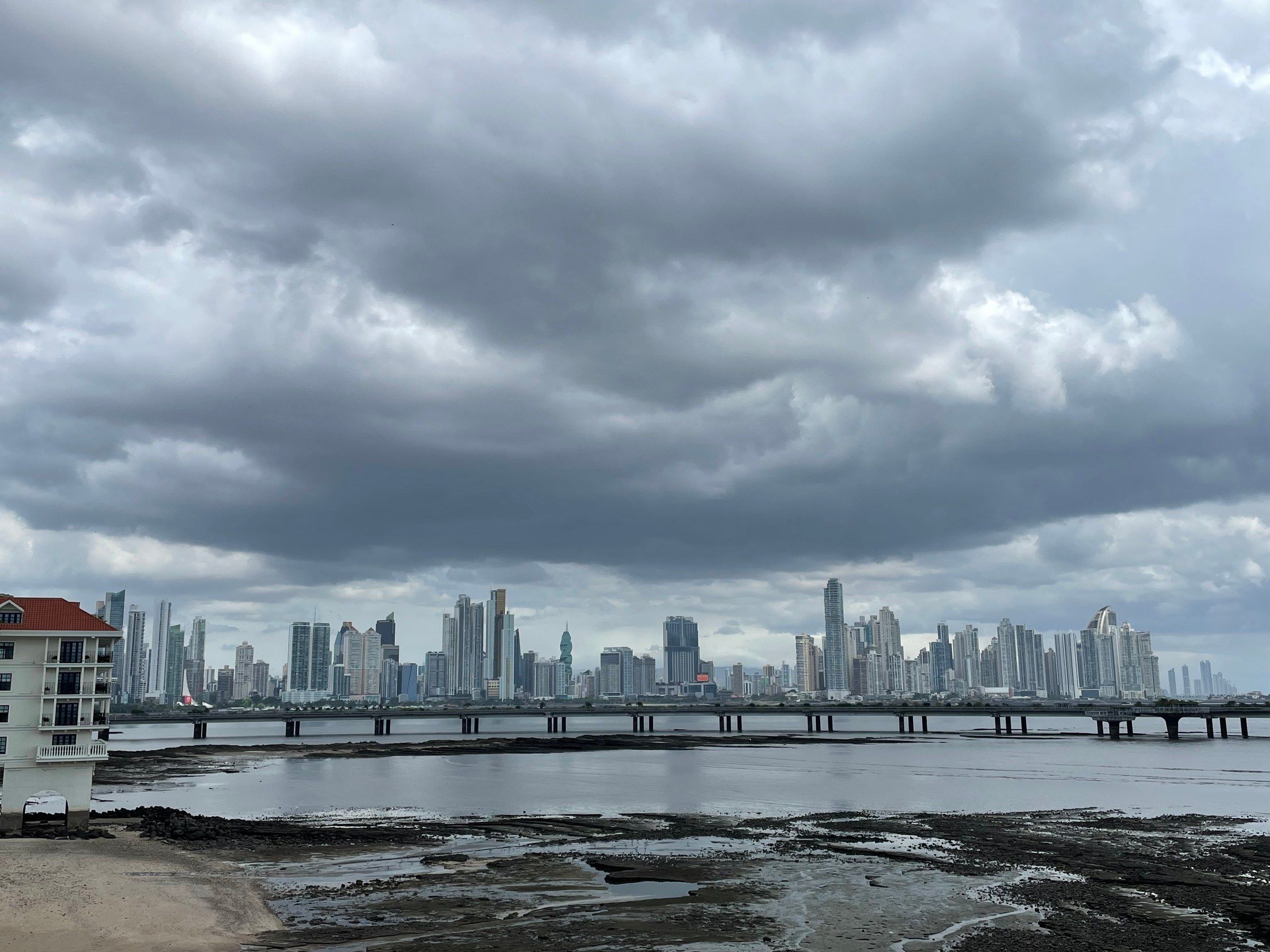The Panama City skyline under a heavy, clouded sky.